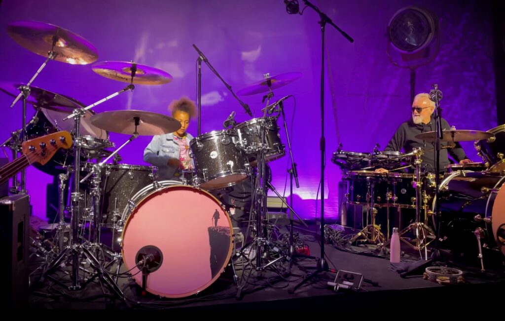Watch Nandi Bushell enter a drum battle with Queen's Roger Taylor