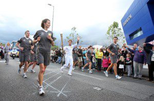 Sir Cliff Richard carries the Olympic Flame on the Torch Relay leg between Smethwick and Birmingham on Day 43 of the Olympic Flame Torch Relay on June 30, 2012 in Birmingham, England.