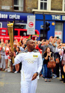 Dylan Mills aka Dizzee Rascal carries the Olympic Flame on the Torch Relay leg between the boroughs of Tower Hamlets and Hackney during Day 64 of the London 2012 Olympic Torch Relay on July 21, 2012 in London, England.