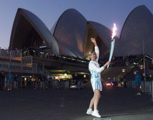 Olivia Newton-John holds the Olympic torch, Sept. 14, 2000 in front of Sydney Opera House.