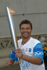 Ryan Seacrest carries the Olympic Flame during Day 12 of the ATHENS 2004 Olympic Torch Relay on June 16, 2004 in Los Angeles, California.