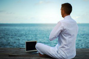 Man in a yoga pose in front of a laptop for story about AI and spirituality