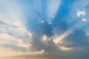 Rays of light penetrate the layers of clouds in the dramatic afternoon sky, formed by the phenomenon of afternoon sunlight passing through the gaps in the cloud formations in the air